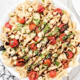 overhead shot of Caprese pasta salad topped with basil in a bowl