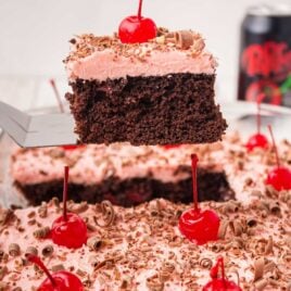 close up shot of a slice of Cherry Dr Pepper Cake topped with a cherry on a spatula