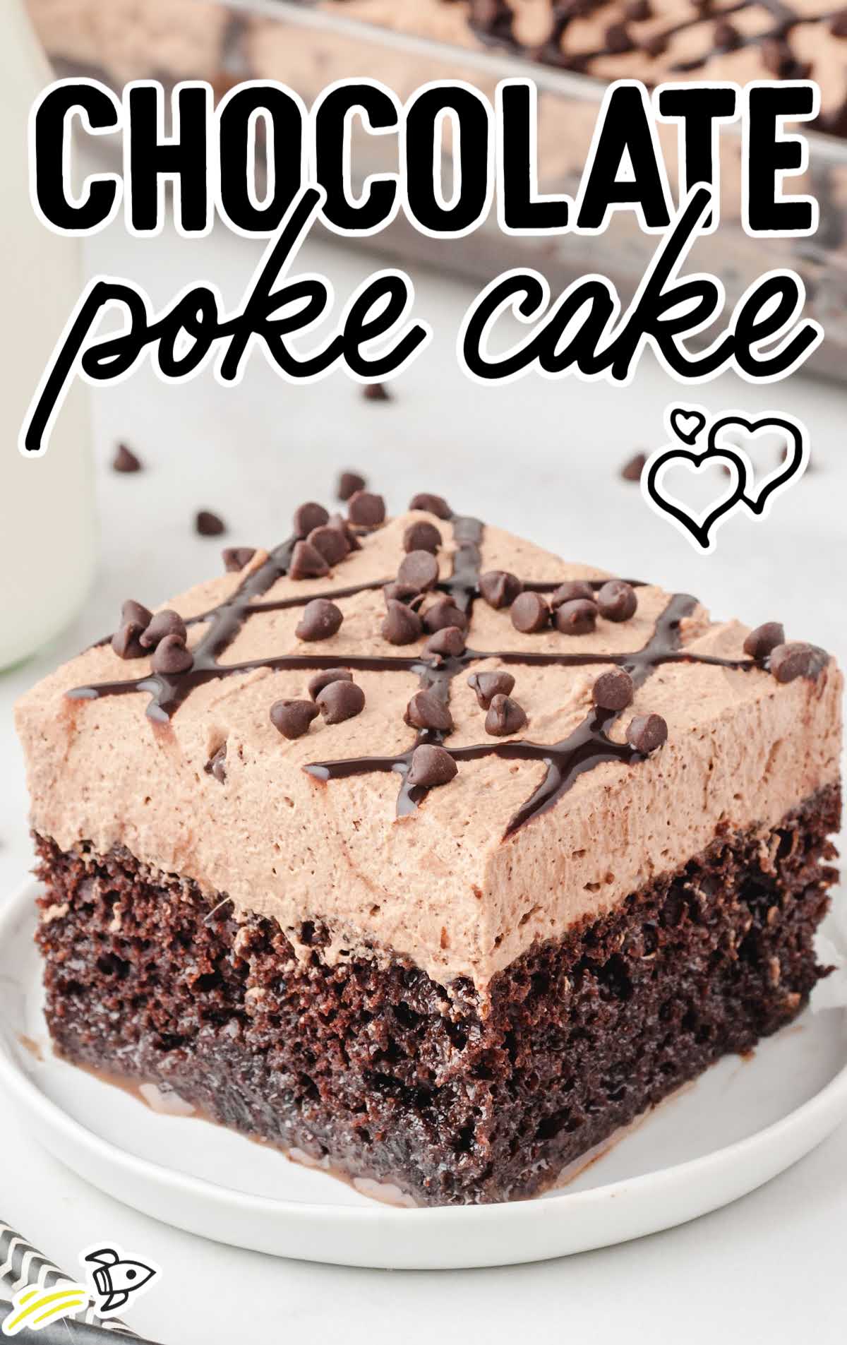 close up shot of a slice of chocolate poke cake garnished with chocolate chips on a white plate