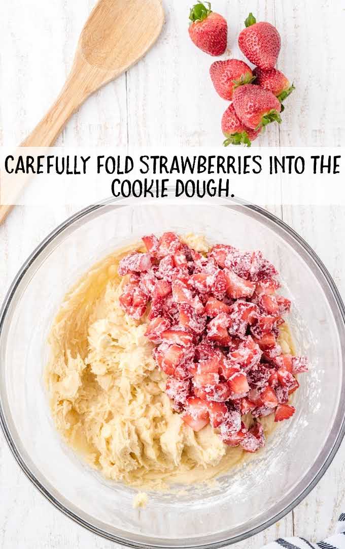strawberries folded into the cookie dough mixture in a bowl