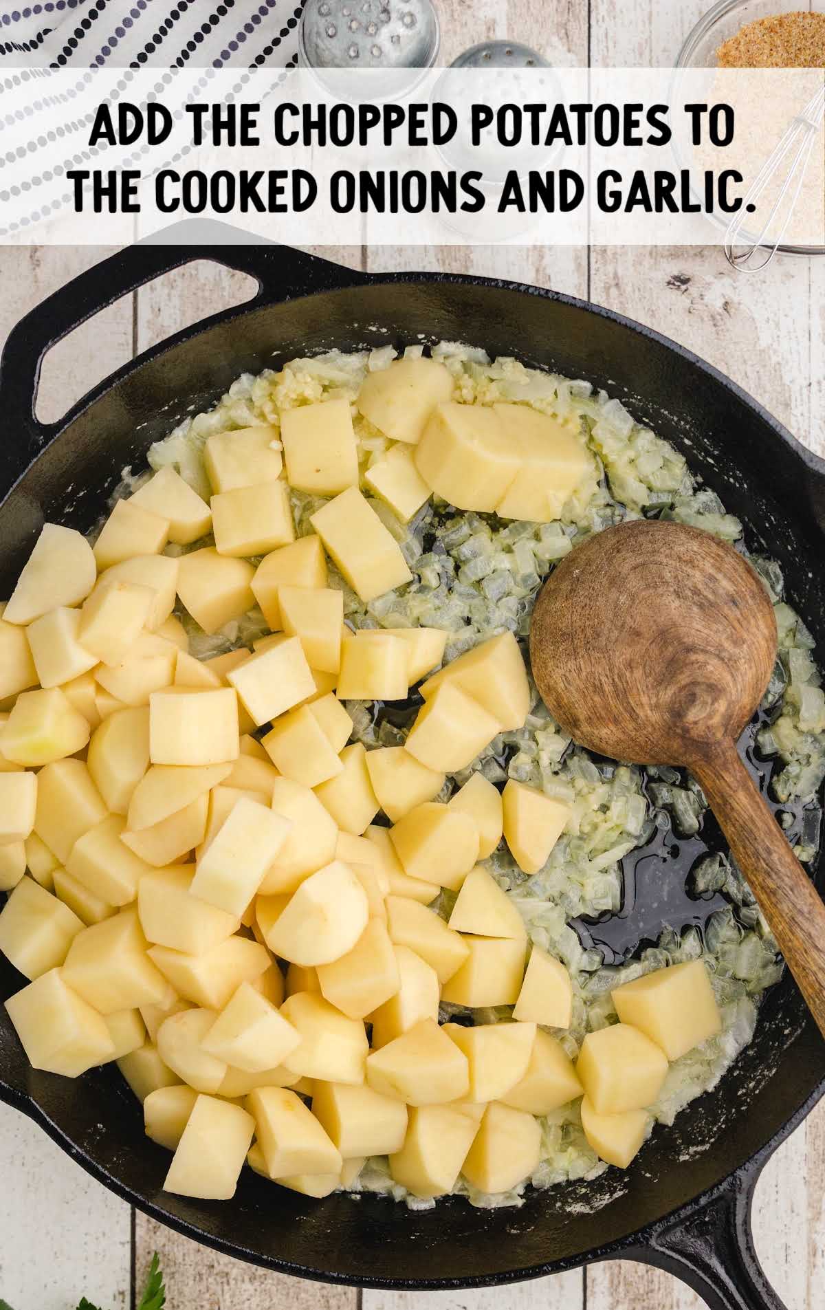 chopped potatoes added to a skillet with onions and garlic