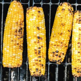 close up shot of grilled corn on the cob on a grill