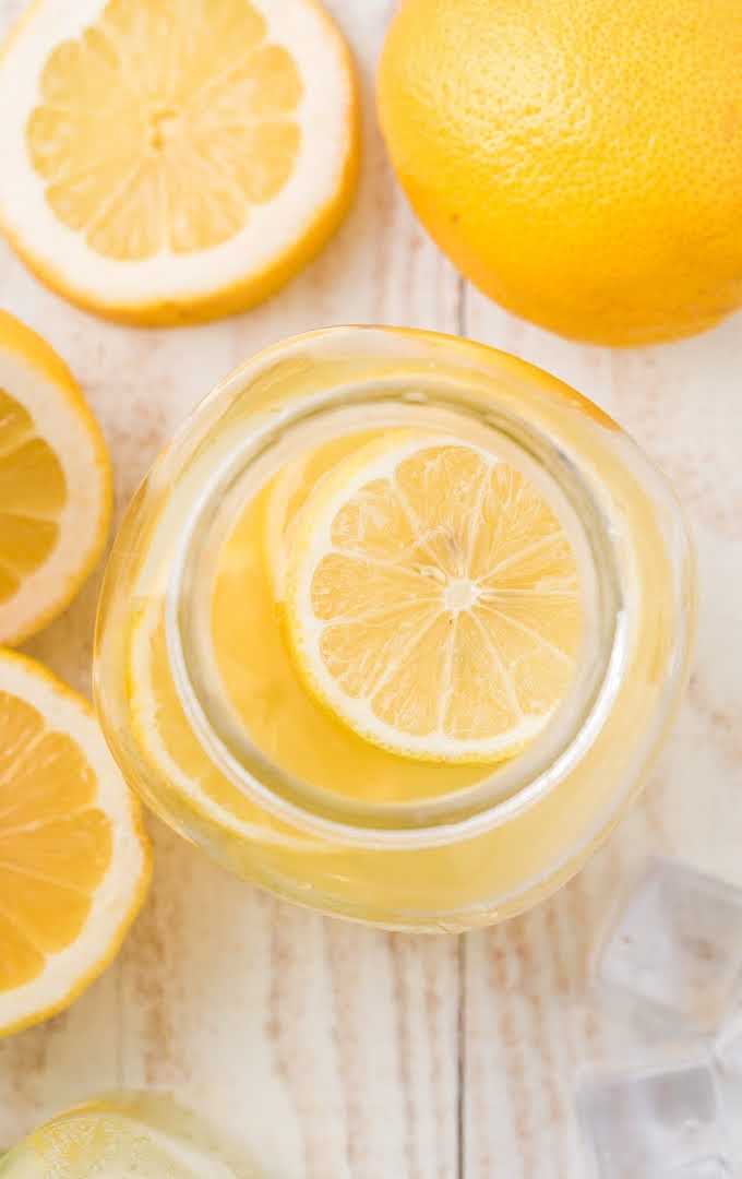 close up overhead shot of hard lemonade in a glass jar with slices of lemon