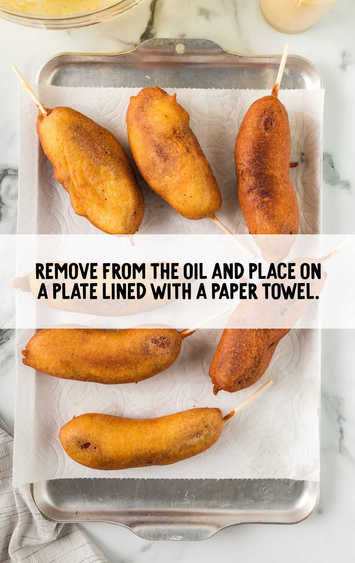 fried corn dogs placed on a plate lined with a paper towel 
