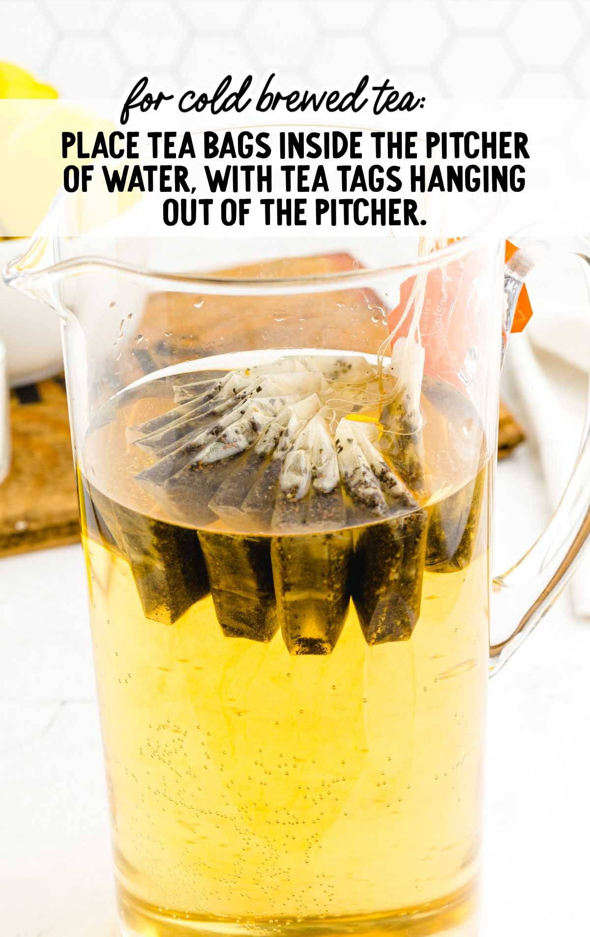 Pitcher filled with cold water and tea bags with text instructions for making cold brewed tea