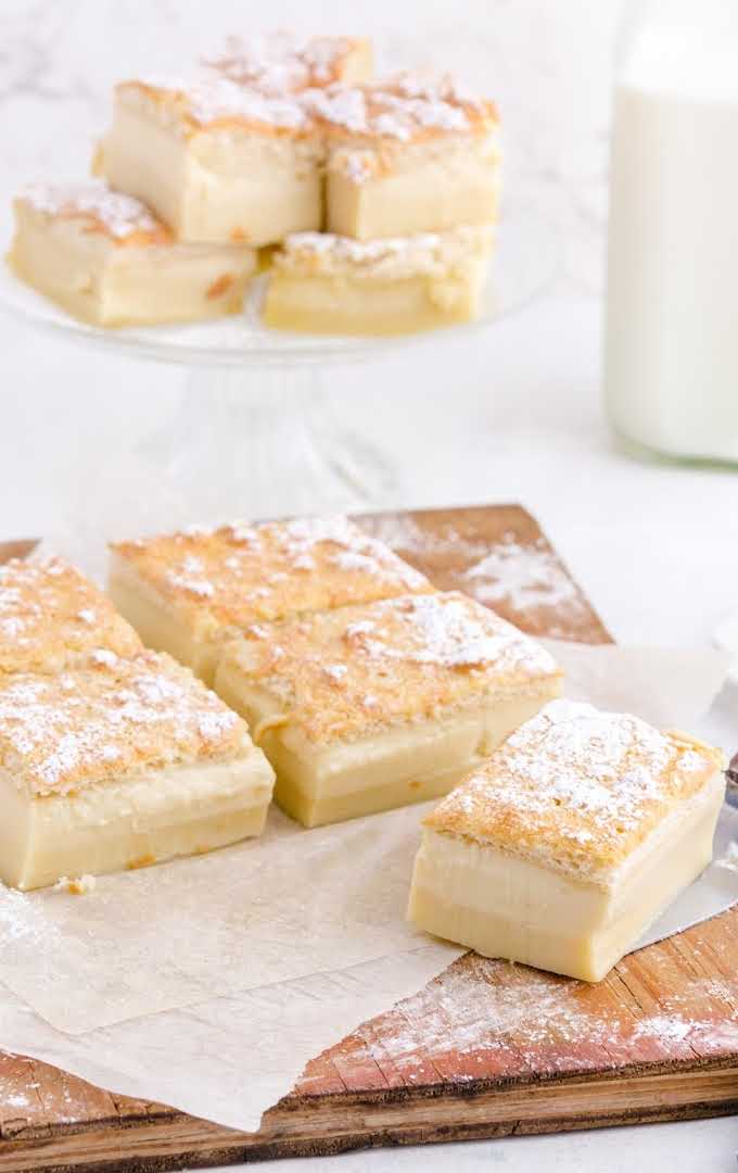 close up shot of slices of magic custard cake on a wooden board