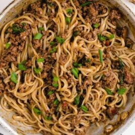 close up overhead shot of a skillet of Mongolian Beef and Noodle Recipe garnished with green onions