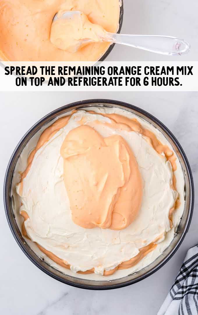 no-bake orange creamsicle cheesecake process shot of orange cream placed on top of cheesecake layer