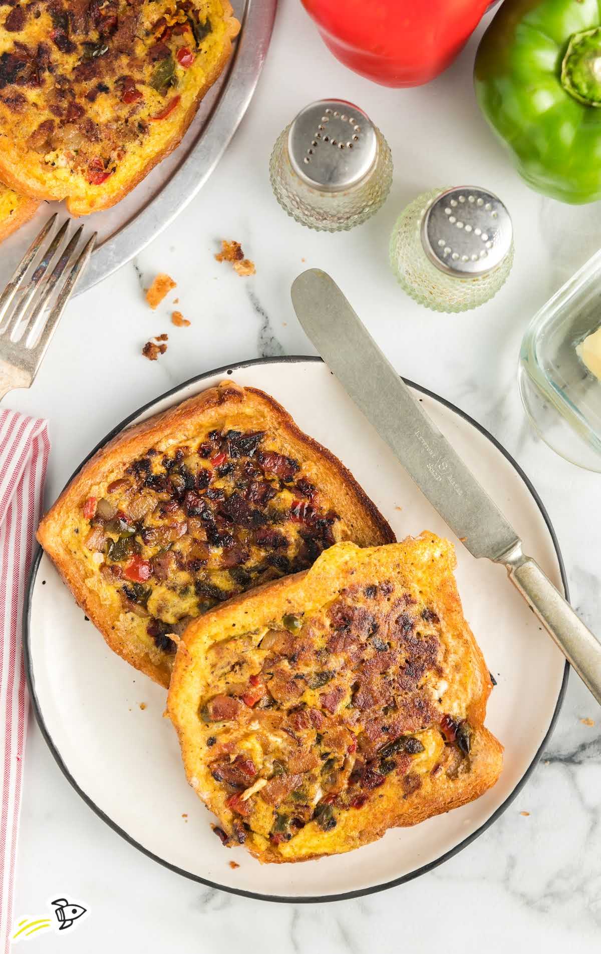 Overhead view of omelet toast with knife, fork, and salt and pepper shakers on the table.