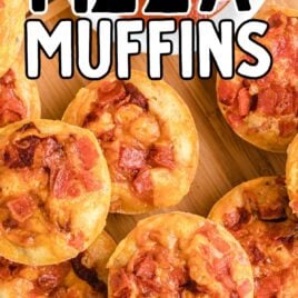 close up overhead shot of Pizza Muffins piled on a wooden board with a bowl of marinara sauce