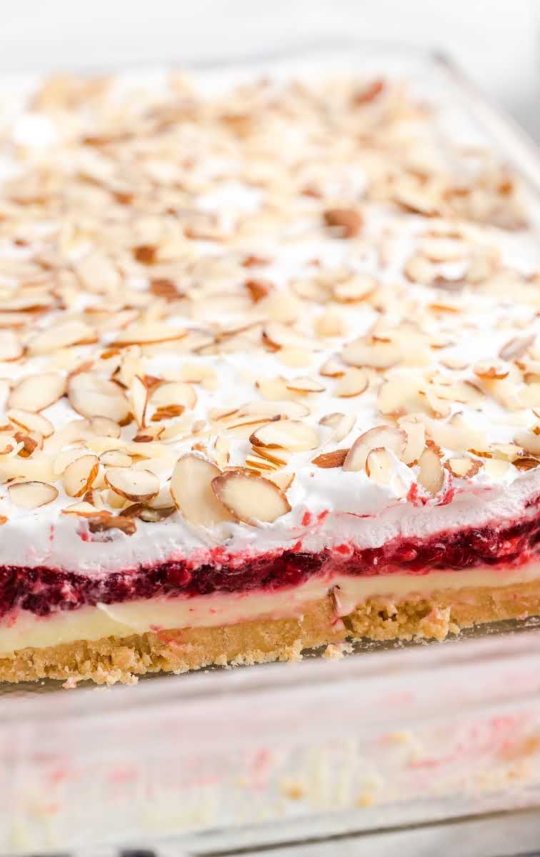 close up shot of raspberry lasagna with almonds in a baking dish