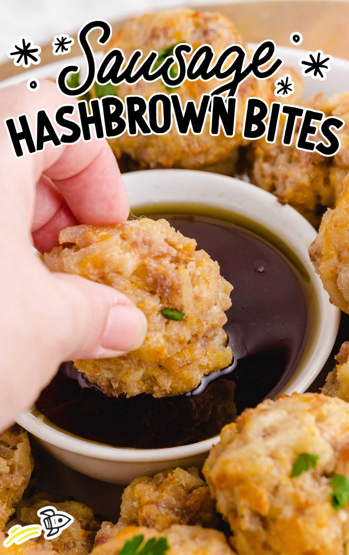 close up shot of hashbrown bites on a white plate with a bowl of syrup