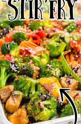 close up shot of sheet pan stir fry topped with sesame seeds and sauce in a sheet pan
