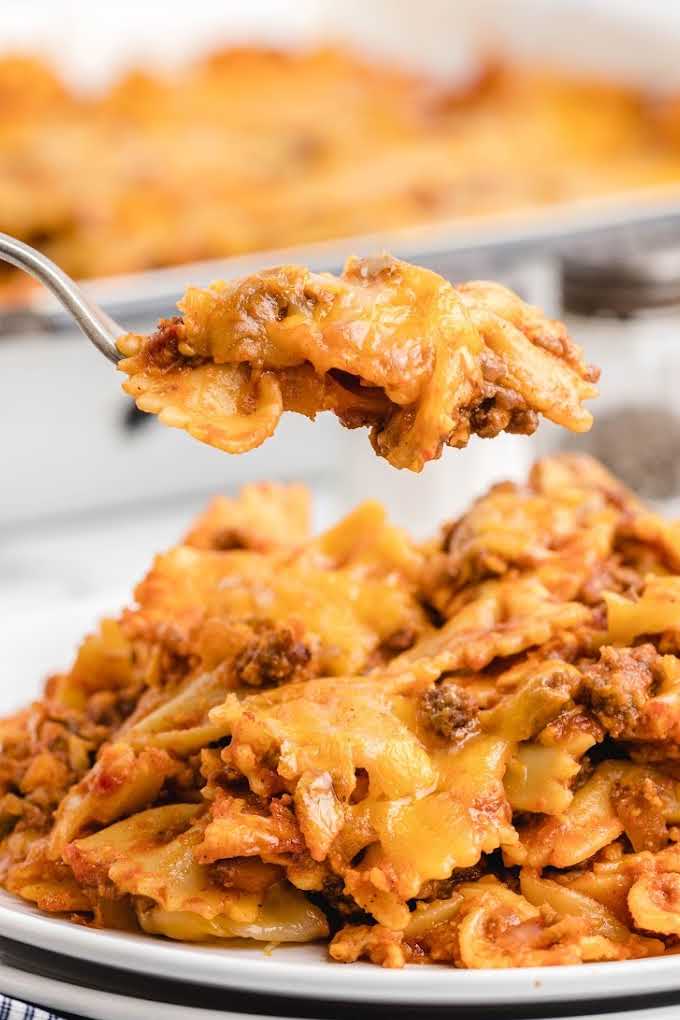 close up shot of a serving of sloppy joe casserole on a plate with a piece being picked up with a fork