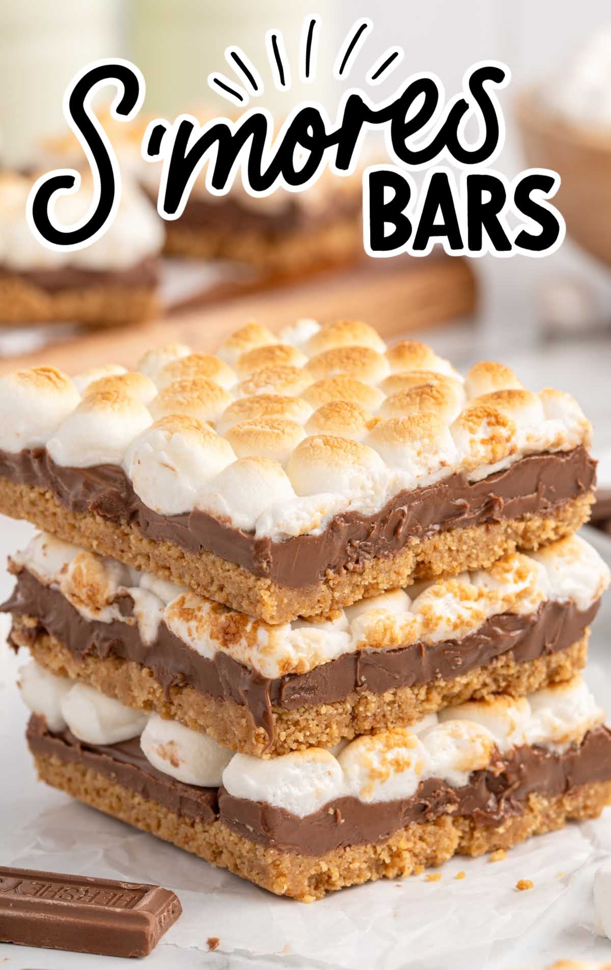 Three stacked s’mores bars with perfectly toasted mini marshmallows and rich melted chocolate on a graham cracker base.