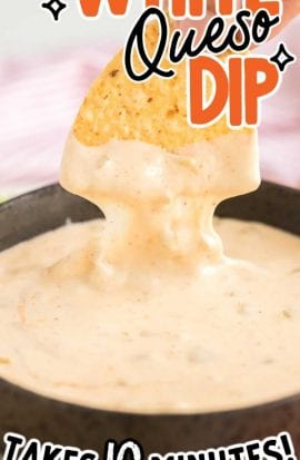 close up shot of a tortilla chip being dipped into a bowl of white queso dip