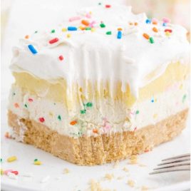 close up shot of birthday cake delight with sprinkles on top on a white plate