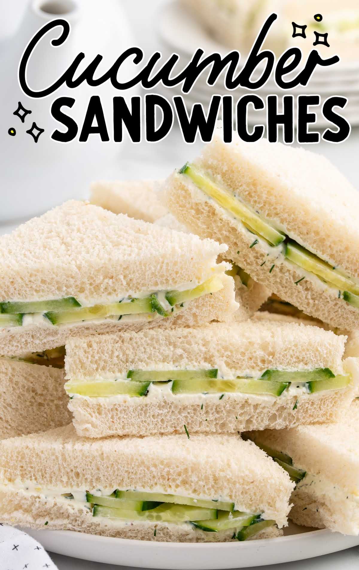 Cucumber sandwich stack on a white plate with the text "Cucumber Sandwiches" overlaid, showing cream cheese and cucumber layers.
