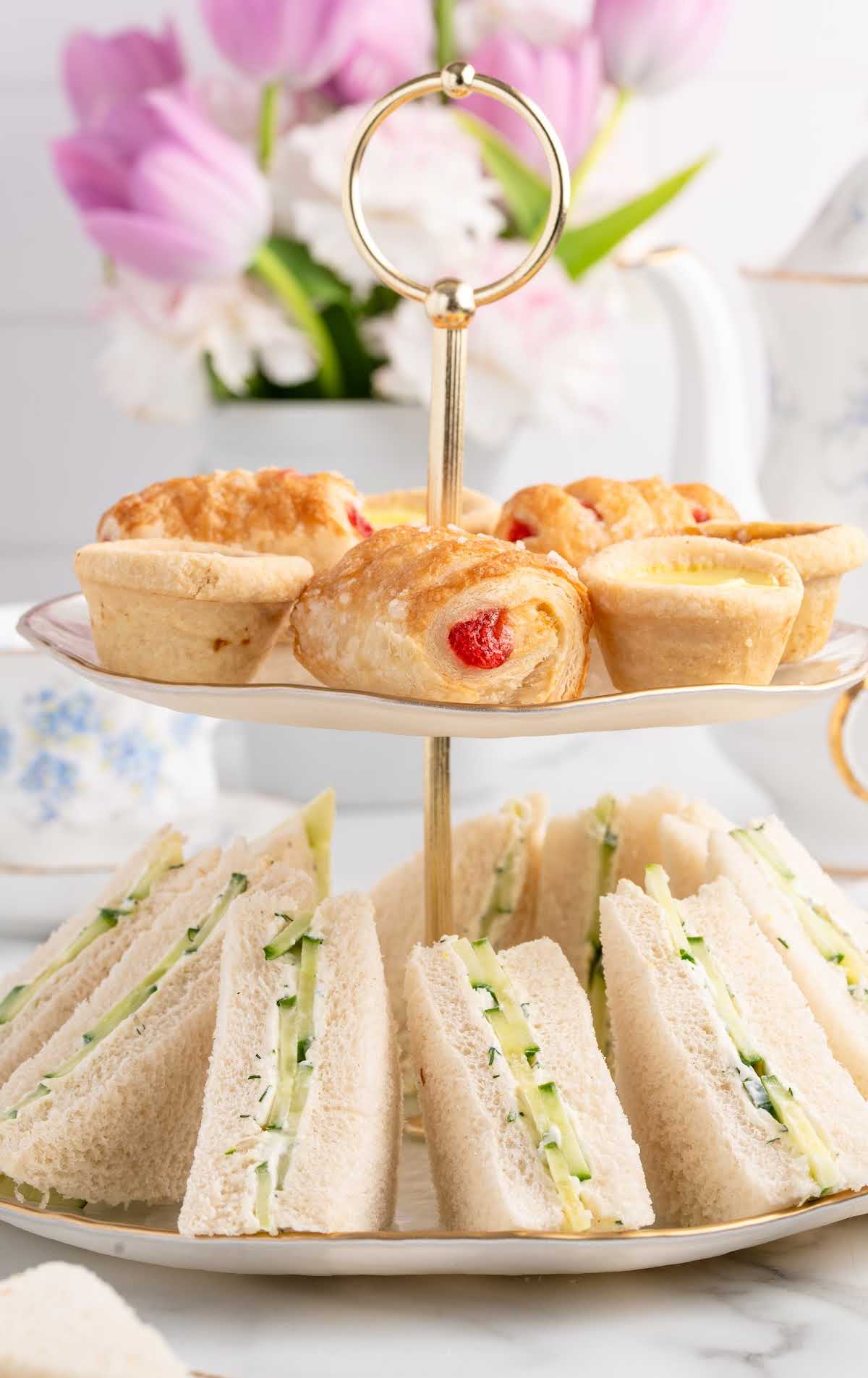 Graphic image with text “How to make tasty cucumber sandwiches for tea parties & showers” and a plate of triangle sandwiches underneath.