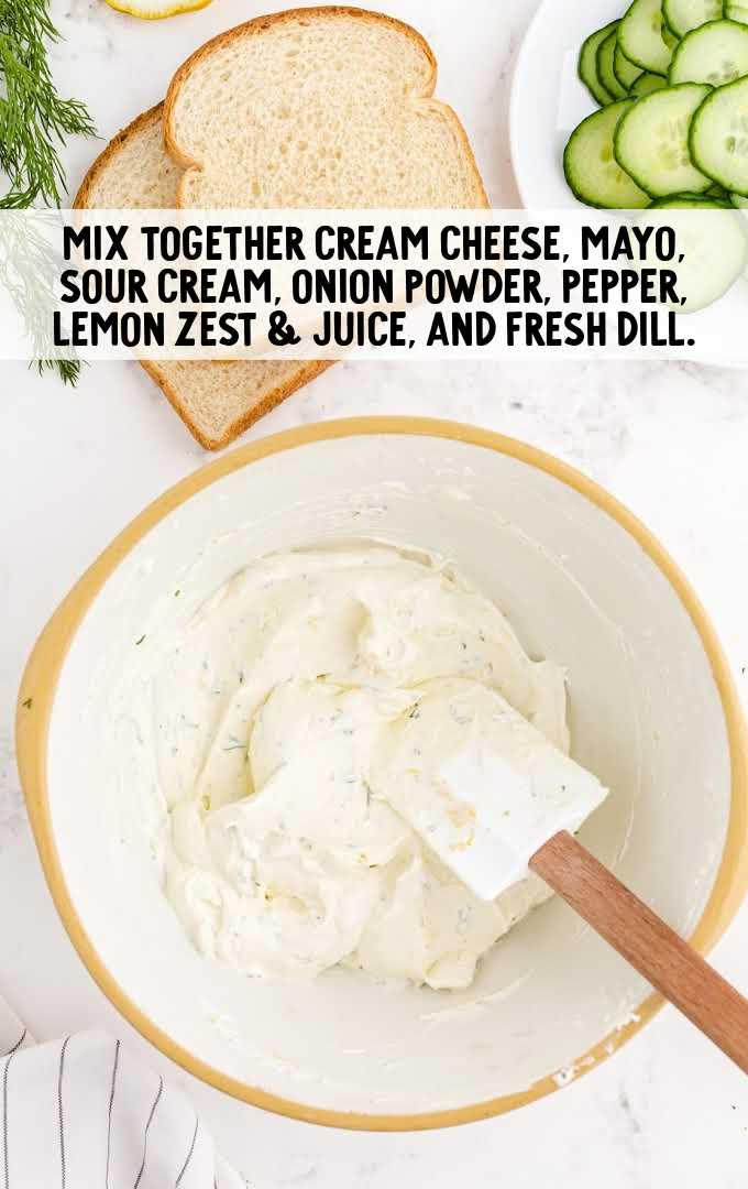 cream cheese, mayonnaise, sour cream, onion powder, black pepper, lemon zest, lemon juice, and fresh dill being combined in a bowl