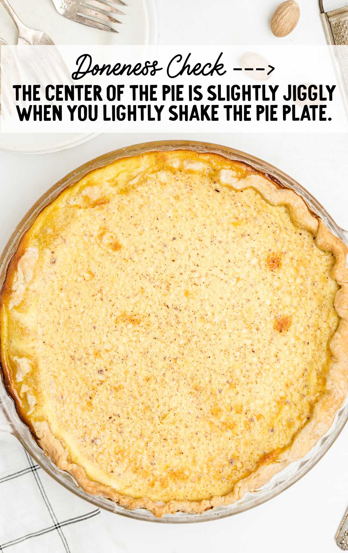 Baked custard pie with note explaining doneness — slightly jiggly center when gently shaken