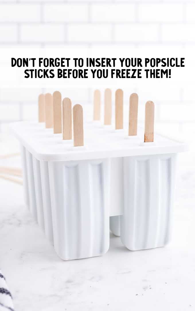 fudgesicles process shot of sticks being inserted into popsicle molds
