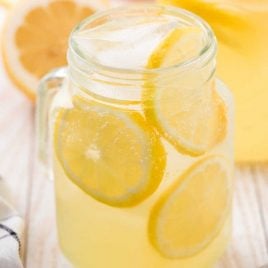 close up shot of hard lemonade in a glass jar with slices of lemon
