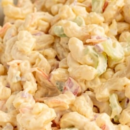 Bowl of elbow macaroni pasta salad with text overlay reading “Ultra Creamy Classic Dressing.”