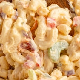 Vintage-style macaroni pasta salad with text overlay reading “70’s Vintage Recipe!” and a wooden spoon scooping from the bowl.