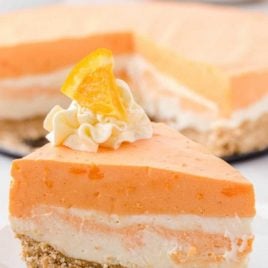 close up shot of a slice of no-bake orange creamsicle cheesecake on a plate