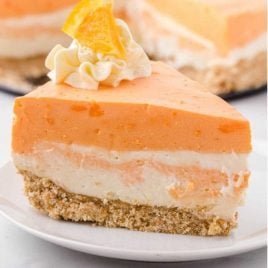 close up shot of a slice of no-bake orange creamsicle cheesecake on a plate