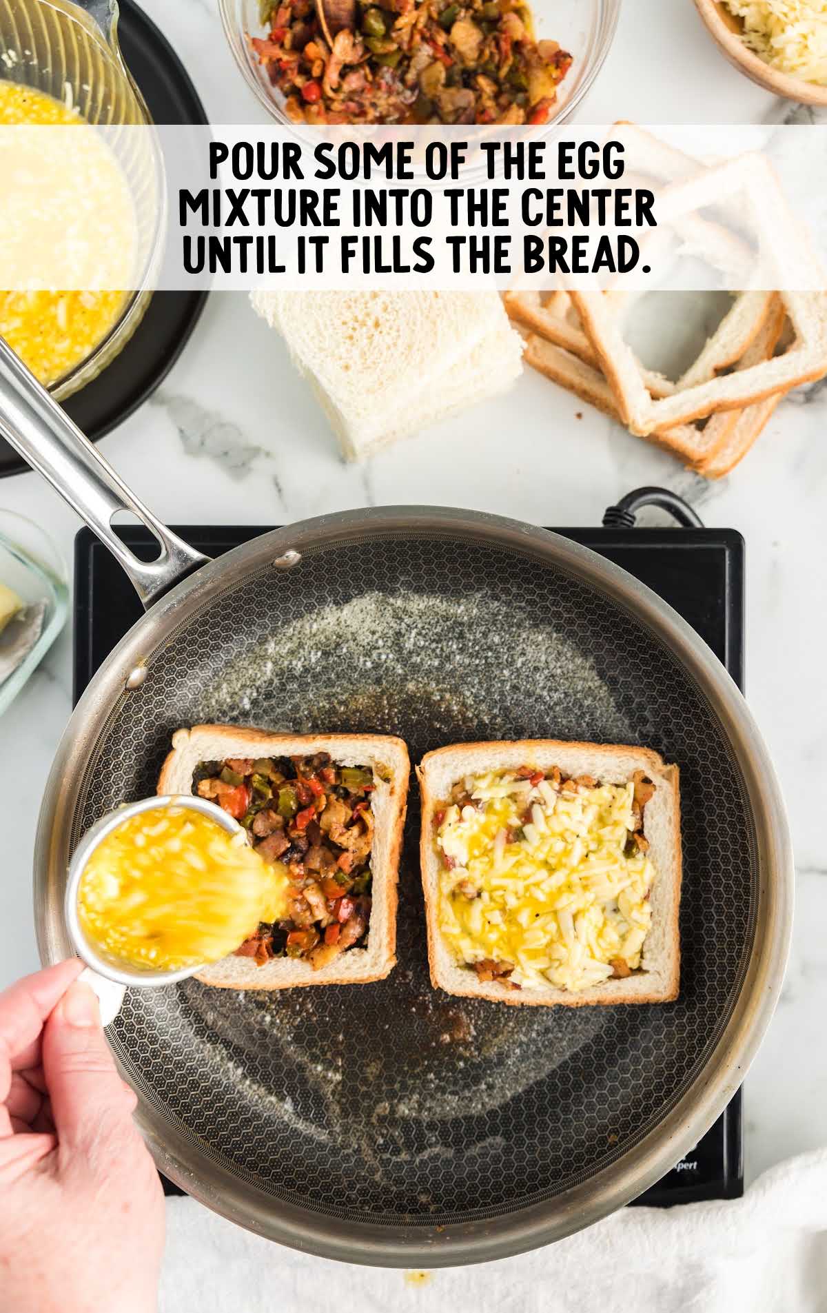 Pouring whisked egg mixture into the center of bread filled with vegetables and bacon.