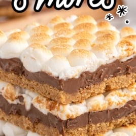 Tall Pinterest-style image of stacked s’mores bars labeled as the perfect recipe for indoor s’mores—soft and gooey.