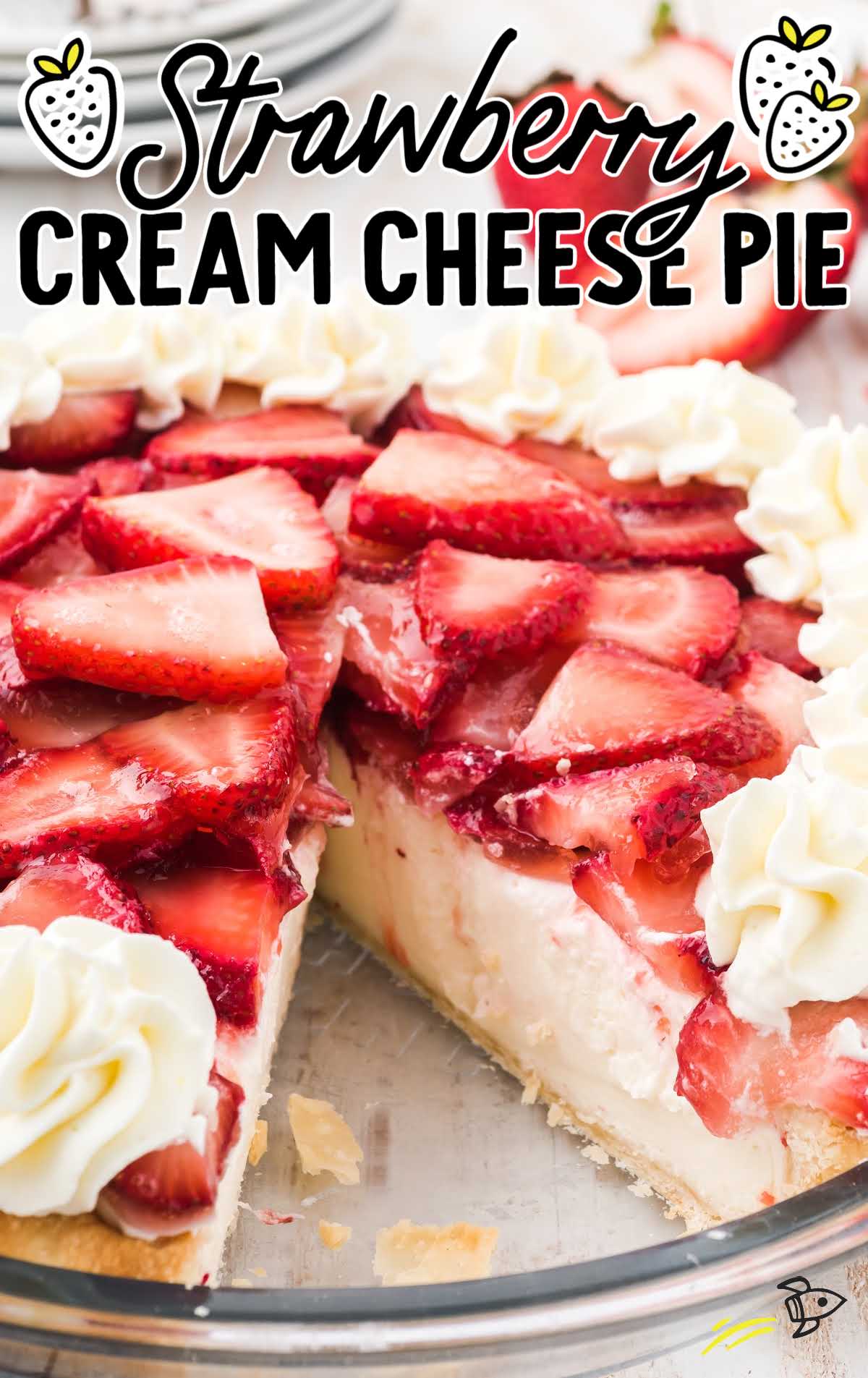close up shot of strawberry cream cheese pie with sliced strawberries and a whipped topping in a clear pie dish