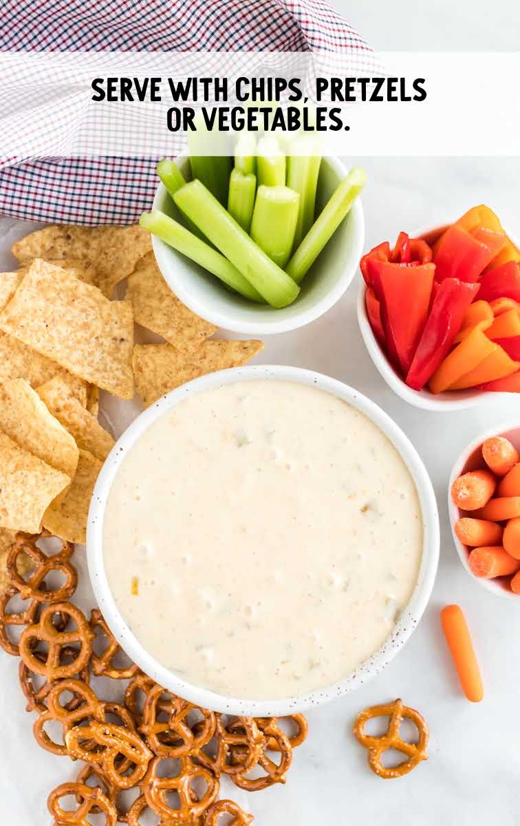 white queso dip process shot of a bowl of dip with dipping sides