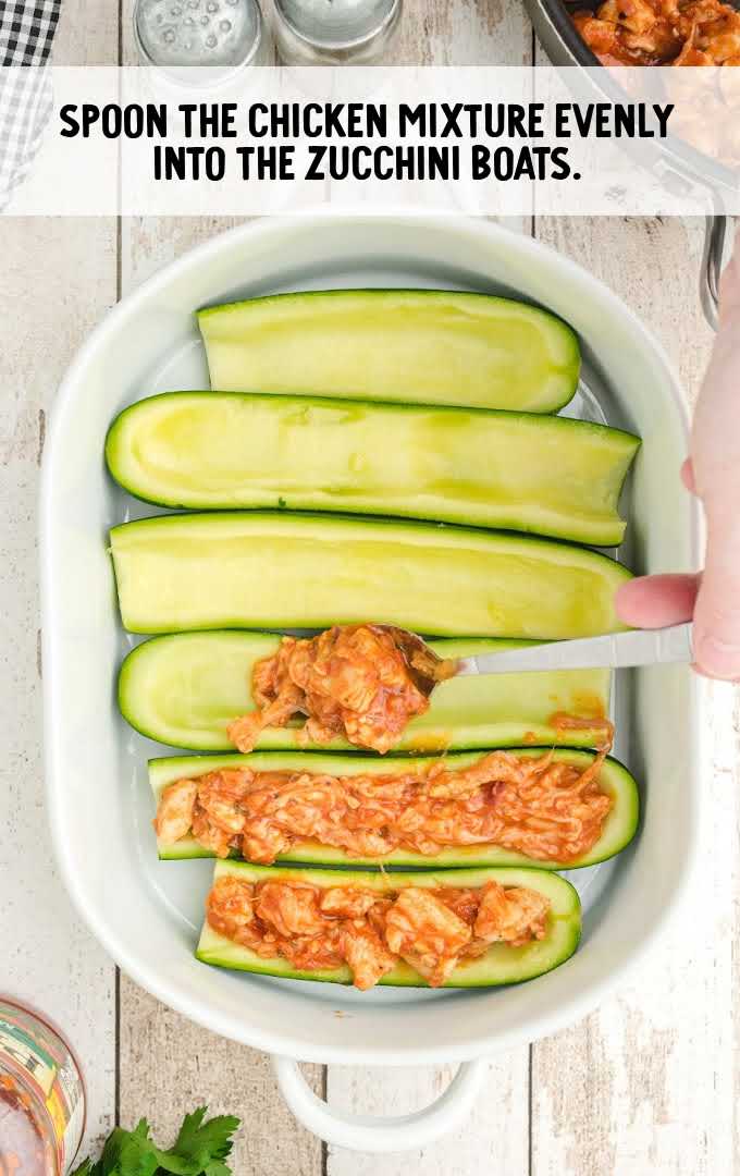 zucchini boats process shot of zucchini being filled with chicken mixture in a baking dish