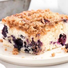 close up shot of slices of blueberry coffee cake piled on top of each other on a plate