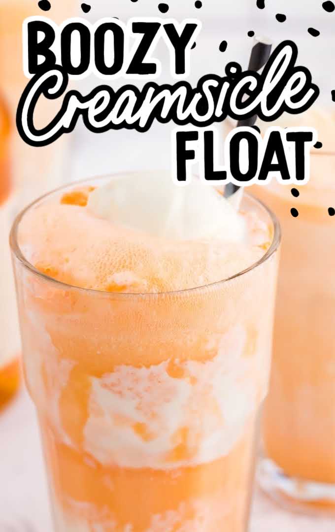close up shot of a glass of boozy creamsicle float with a straw