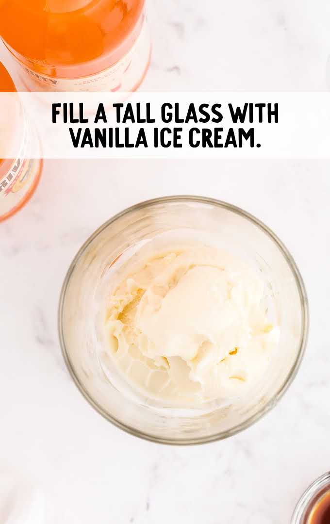 boozy creamsicle float process shot of vanilla ice cream in a glass cup