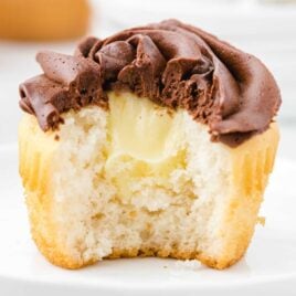 close up shot of a chocolate frosted cupcake showing it's inside Boston Cream filling