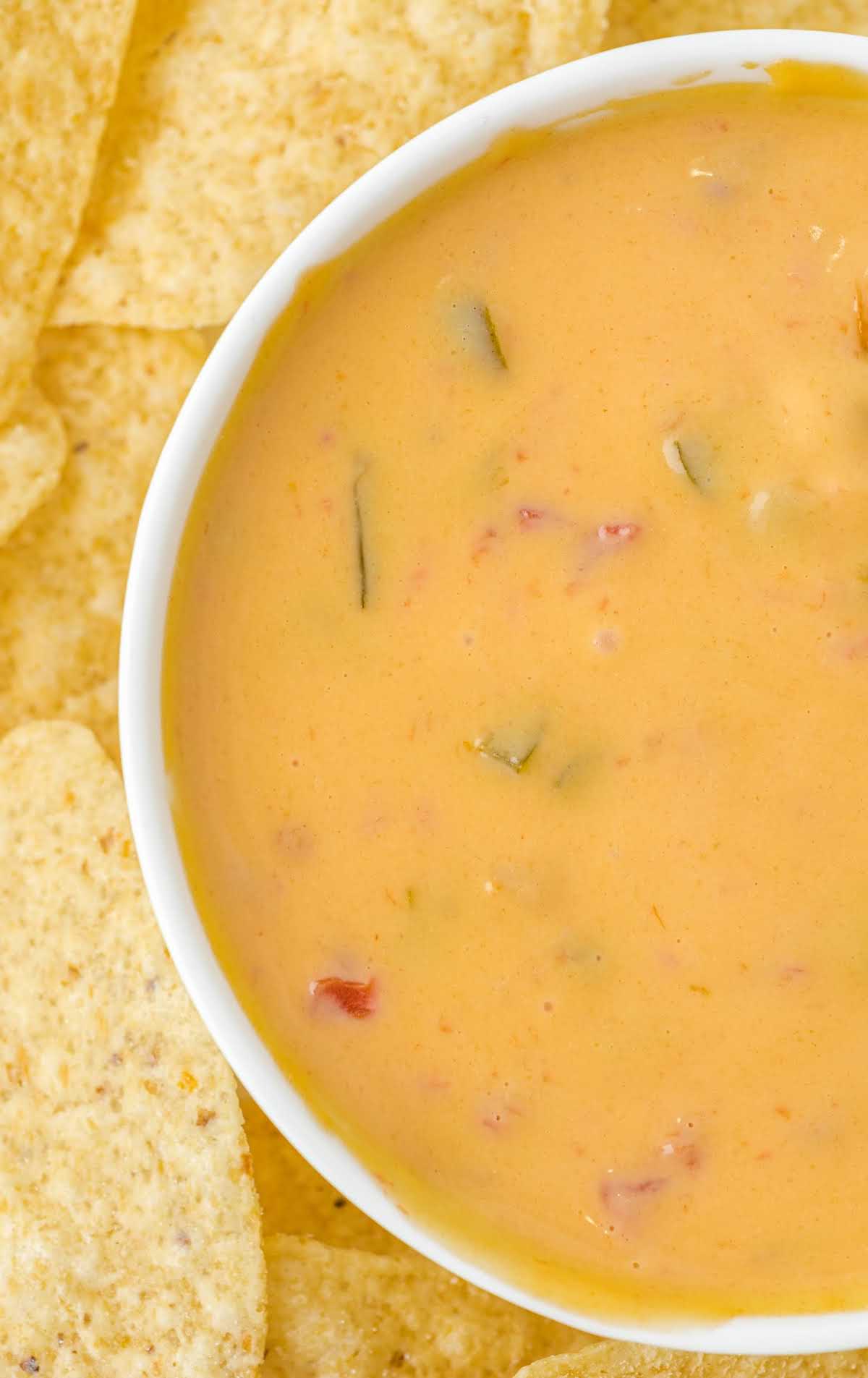 close up shot of a bowl of Cheese Dip with tortilla chips