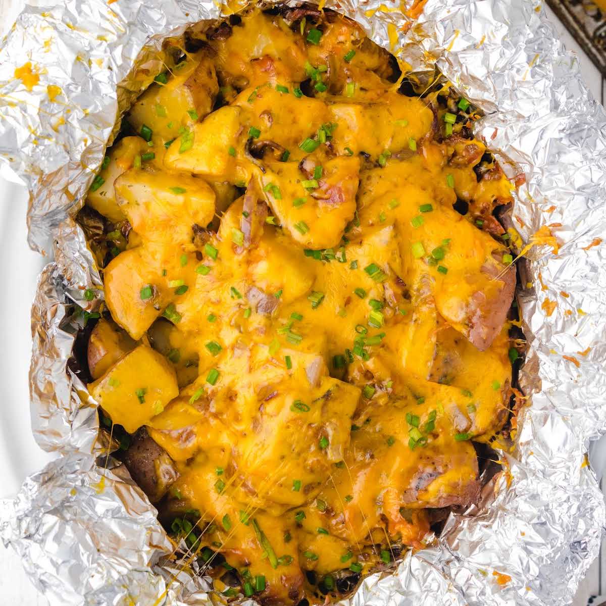 cheesy bacon ranch potatoes garnished with chives in a crockpot