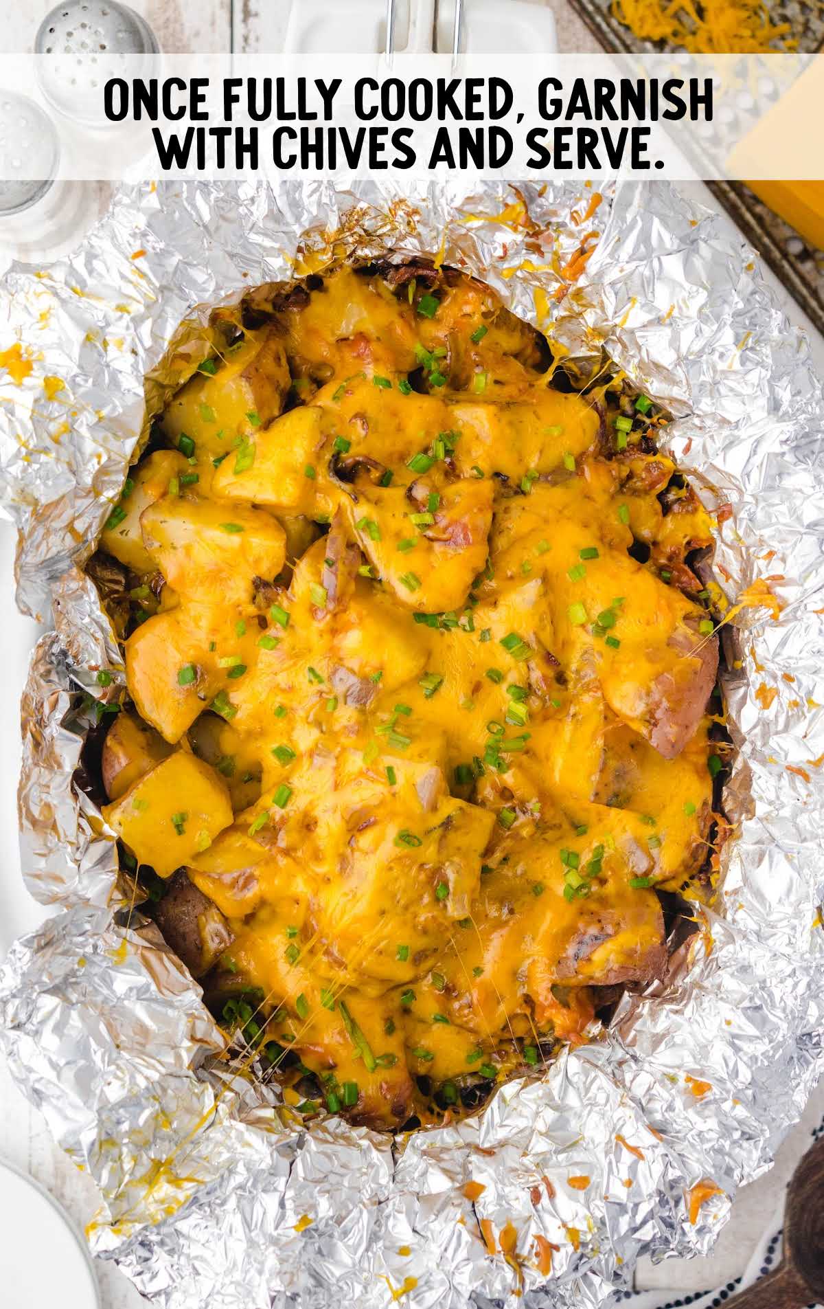 cheesy potatoes topped with chives in a crock pot