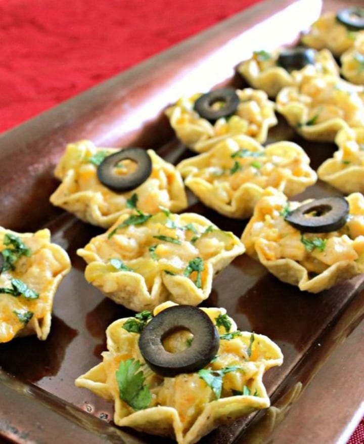 little corn chip cups filled with chicken nacho filling and topped with a sliced black olive