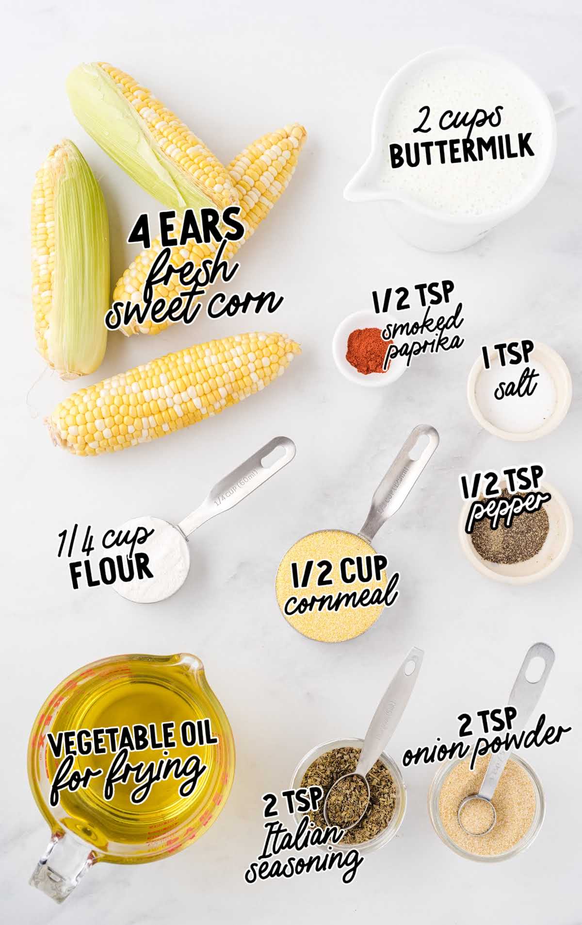 Flat lay of labeled ingredients for fried corn on the cob including fresh corn, cornmeal, flour, and spices