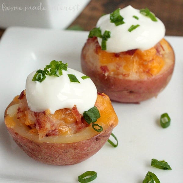 red potato cut in half and filled with cheese and bacon and topped with sour cream and green onions