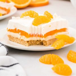 close up shot of a slice of Orange Creamsicle Lush topped with mandarin oranges on a plate