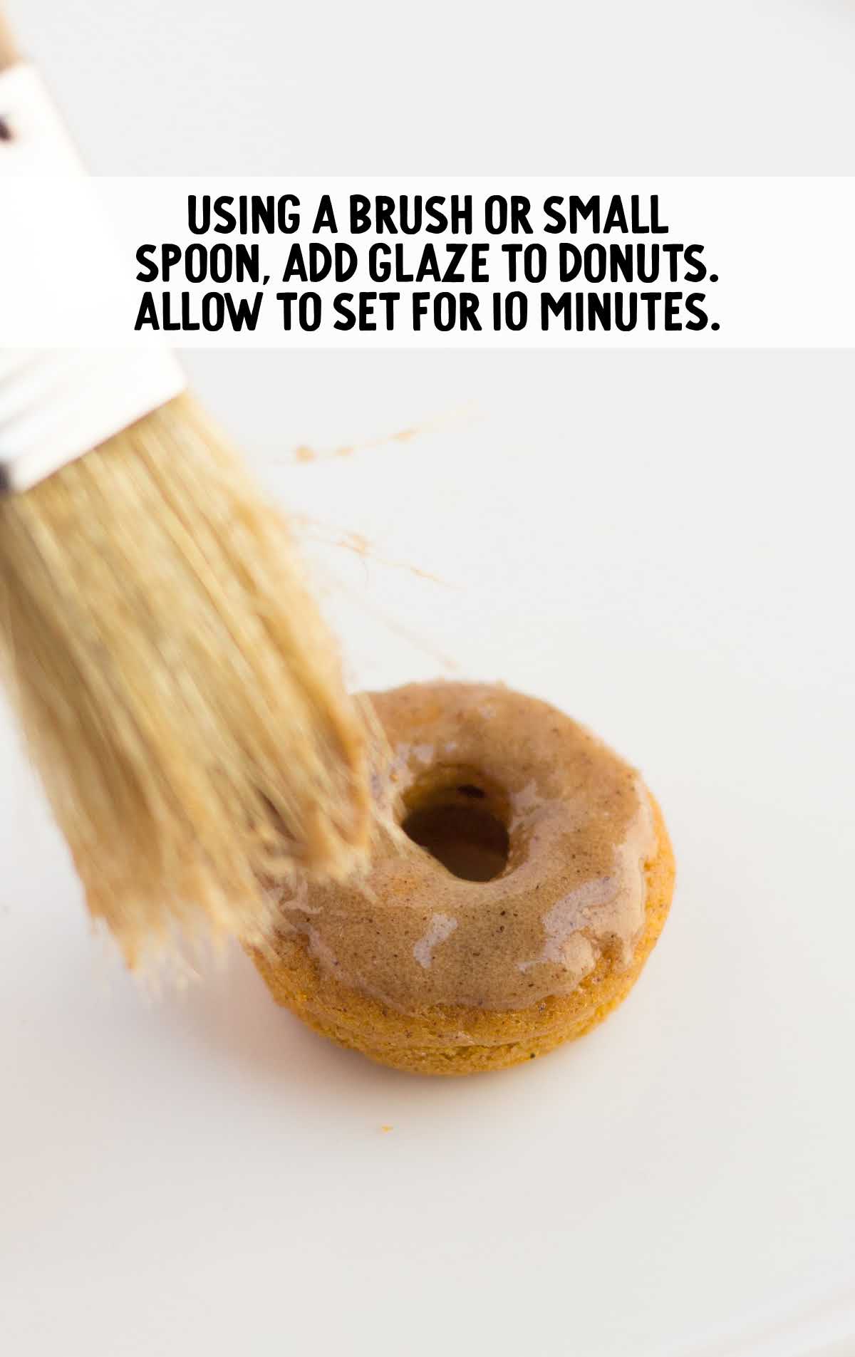 glaze being brushed onto donut