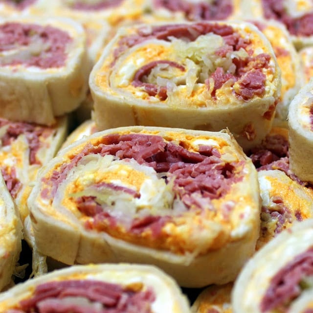 tortillas filled with cream cheese, corned beed, sauerkraut, and Russian dressing rolled up and sliced then placed on a platter on top of each other