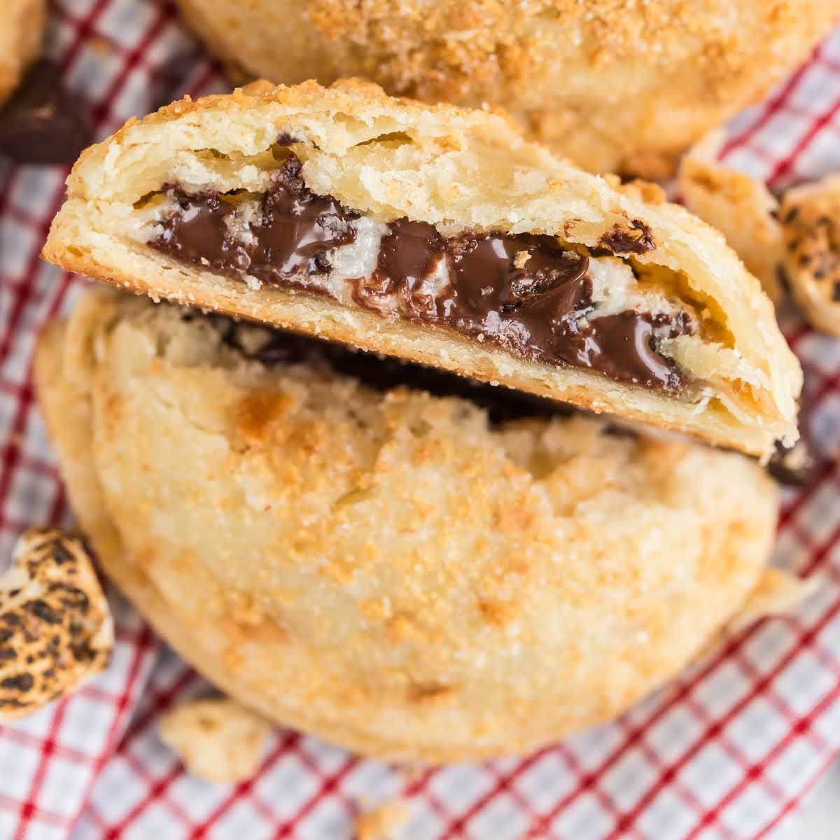 close up shot of a S'mores Hand Pies cut in half showing it's inside chocolate layers